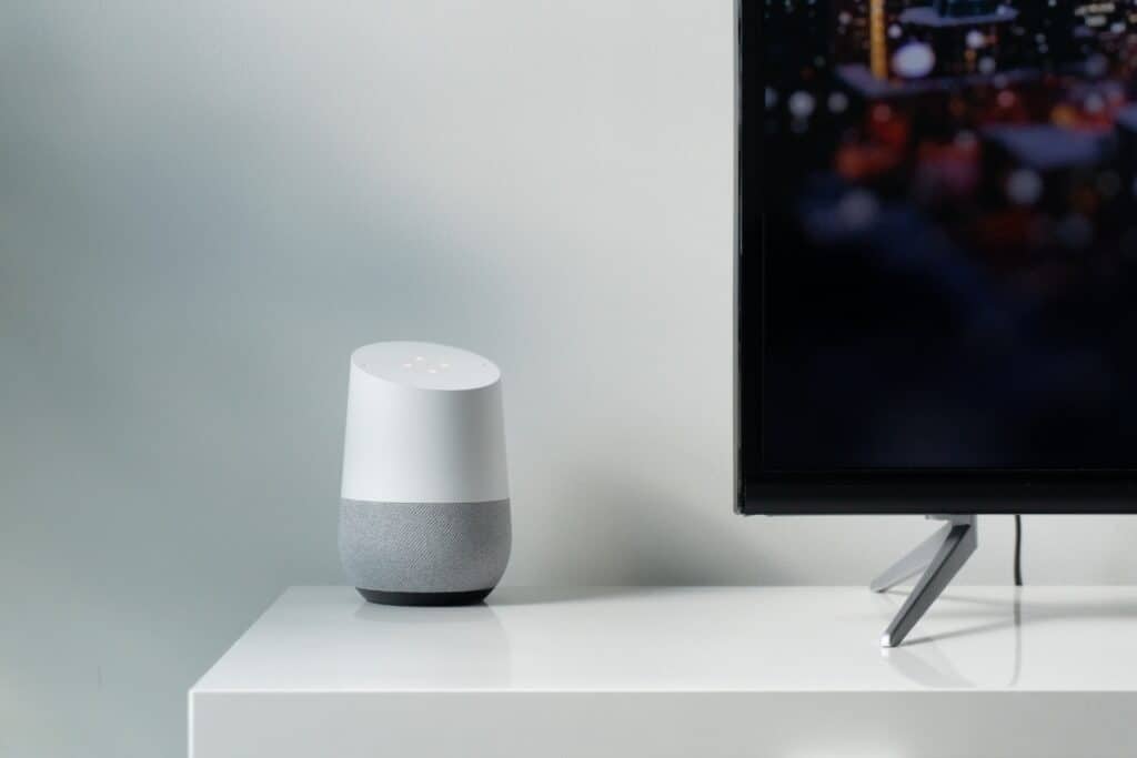 google assistant home hub on table next to television